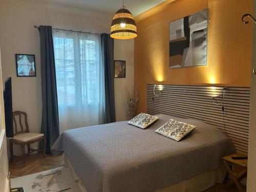 une chambre avec un lit avec deux oreillers dessus dans l'établissement Joli et lumineux appartement proche mer et centre ville Nice, à Nice