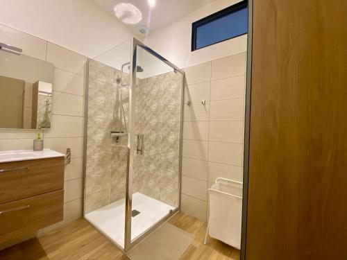 une salle de bain avec une douche avec une porte vitrée dans l'établissement Splendide et convivial 8 personnes hyper centre, à Cauterets