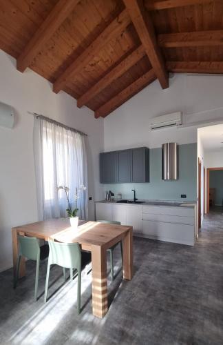 a kitchen with a wooden table and some chairs at Skyview Family Lodge in Mezzocorona