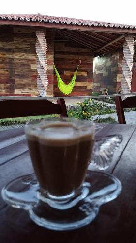 a cup of coffee sitting on top of a table at Chalés Passagem do Canto in Barreirinhas