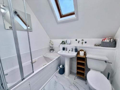 a bathroom with a sink and a toilet and a tub at Pepperpot Lakeside Lodge on Isis & Windrush Lakes in the Cotswold Lakes in South Cerney