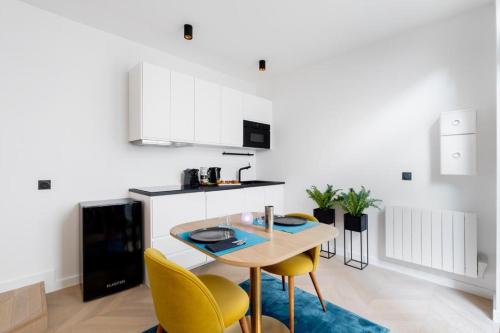 une cuisine avec une table et des chaises jaunes dans l'établissement Le Jean Jaurès - Studio cosy au cœur de Boulogne, à Boulogne-Billancourt