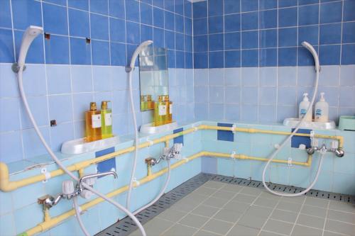 a blue tiled bathroom with a shower in it at Snow Freak Sunrise in Zao Onsen