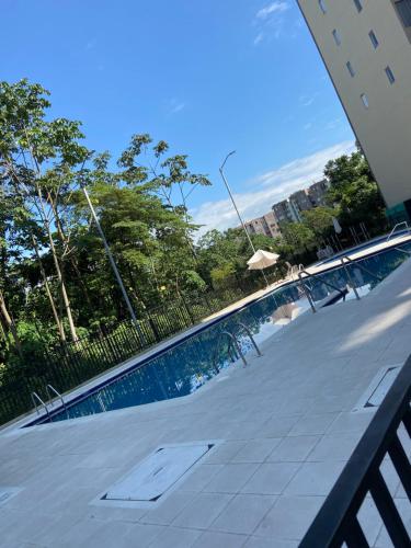 una piscina con sillas y sombrilla en Apartamento Nuevo con Piscina Bien Ubicado, en Villavicencio