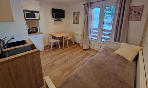 un salon avec une cuisine et une table dans l'établissement Centre Station - La Vallée Blanche 2 - La Foux, à Allos