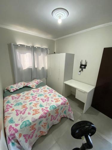 a bedroom with a bed and a chair and a desk at Trindade Beach House in Paraty