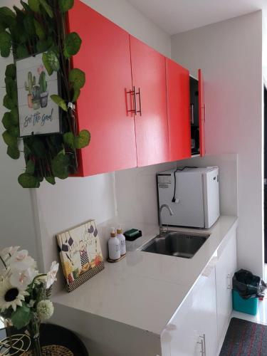 a kitchen with red cabinets and a sink at Serenity Homes with Indoor Jacuzzi in Lipa