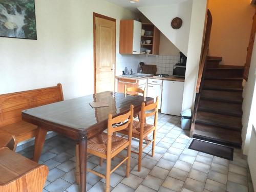 une cuisine avec une table et des chaises ainsi qu'un escalier dans l'établissement Le Moulin Rose, à Chirens