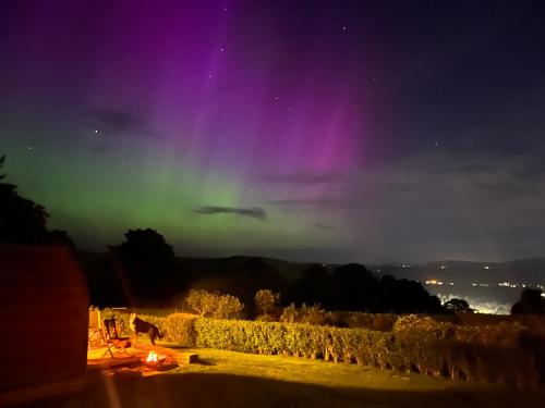 an aurora in the sky over a city at night at Stoneymollan over Loch Lomond in Balloch