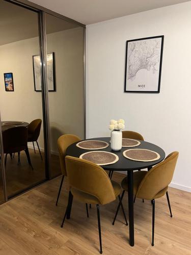 une salle à manger avec une table noire et des chaises jaunes dans l'établissement Olympie, airport, train and tram station Fully equipped for 3 peoples, à Nice