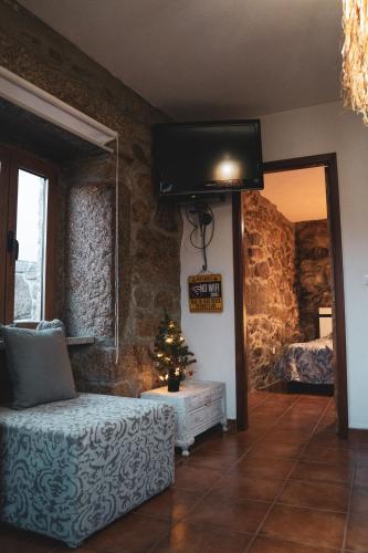 a room with a tv and a couch and a christmas tree at Casa da Cris in Cotelo