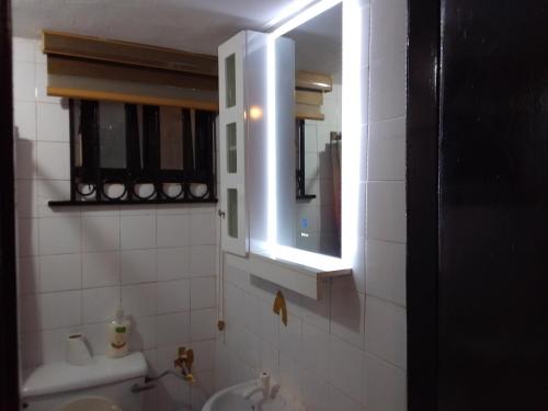 un baño con lavabo y espejo en Moricol Lodge, en Lekki