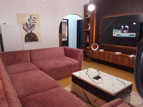 Una sala de estar con un sofá y un televisor. en Moricol Lodge, en Lekki