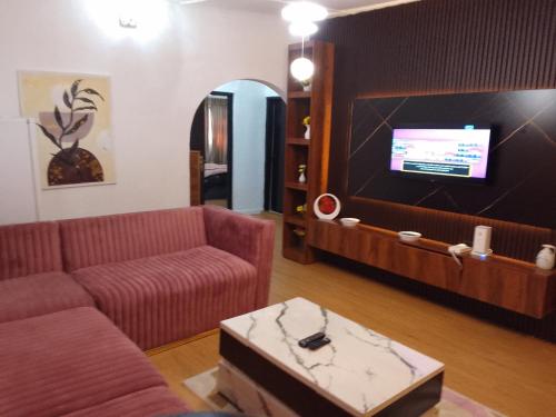 Una sala de estar con un sofá y un televisor de pantalla plana. en Moricol Lodge, en Lekki