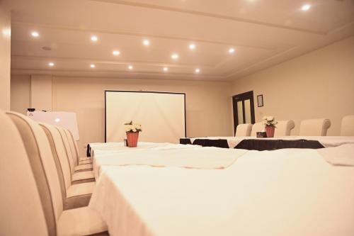 a room with white tables and chairs and a mirror at Best Western Faisalabad in Faisalabad
