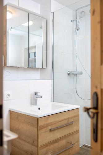 a bathroom with a sink and a shower with a mirror at Defereggerhof St Veit in Defereggen in Feld