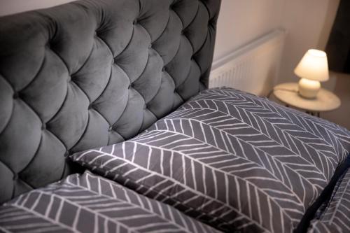 a bed with a gray headboard and a pillow at Defereggerhof St Veit in Defereggen in Feld