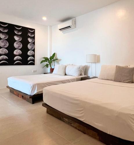 a bedroom with two beds and a painting of wine barrels at Beachfront Apartment with Two Queen Beds, Kitchen and Balcony in Boracay