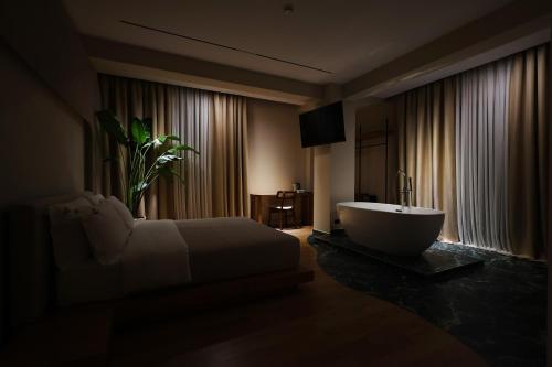 a bedroom with a bed and a tub in a room at Beratinus1 in Berat