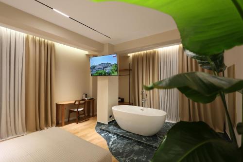 a bathroom with a tub and a tv in a room at Beratinus1 in Berat