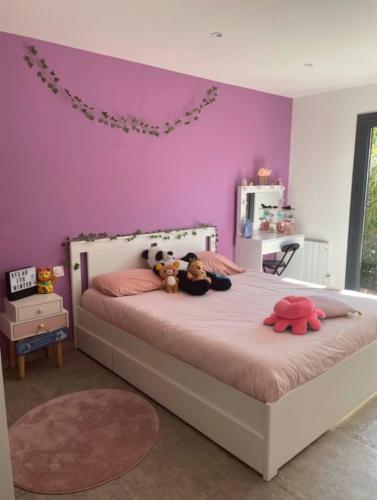 une chambre avec un lit avec deux animaux en peluche dessus dans l'établissement villa avec Piscine, à Gardanne