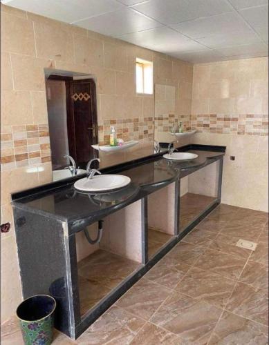a bathroom with two sinks and two mirrors at Wadi Rum Travel camp in Wadi Rum