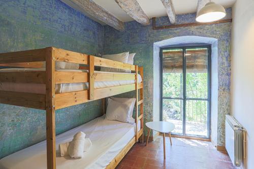 a bedroom with two bunk beds and a window at Charming barn in Mas Simon in Santenys