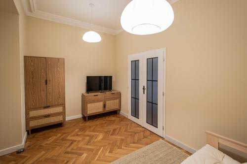 a living room with a television and a dresser at Radost Residence The Heart of Unique Living in Prague