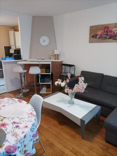 - un salon avec un canapé et une table fleurie dans l'établissement Ici, on y revient par plaisir, à Douarnenez