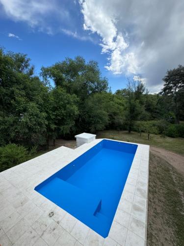 a blue swimming pool on a patio with trees at Cabañas Nueve Alamos in Casa Grande