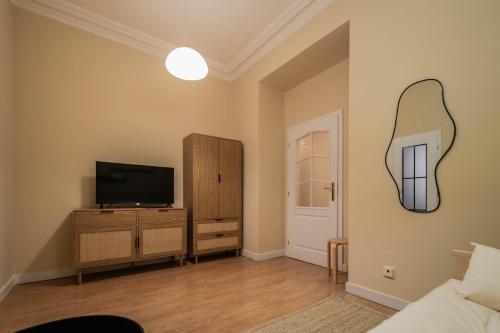 a living room with a television and a mirror on the wall at Radost Residence The Heart of Unique Living in Prague