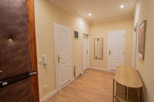 a hallway with white doors and a wooden floor at Radost Residence The Heart of Unique Living in Prague