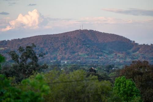 a mountain with a cross on top of it at Tree Tops on Hodge in Albury