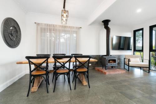 a dining room with a table and chairs and a stove at Tree Tops on Hodge in Albury