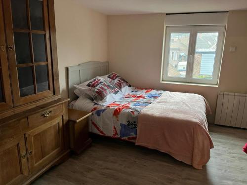 a bedroom with a bed and a dresser and a window at Appartement calme, frais à louer, nouvellement repeint, emplacement stratégique, proche de toutes commodités, de l'autoroute, valenciennes, lille, Belgique, wifi, Netflix, parking Gratuits in Raismes