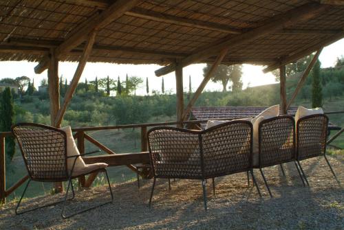 a group of chairs sitting under a gazebo at Agriturismo Podere Alberese in Asciano