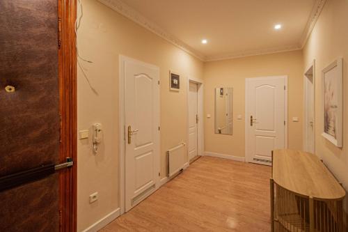 a hallway with white doors and a wooden floor at Radost Residence The Heart of Unique Living in Prague