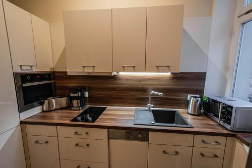 a kitchen with a sink and a microwave at Radost Residence The Heart of Unique Living in Prague