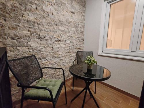 a room with a table and chairs and a brick wall at Surčin Central Stay in Surčin
