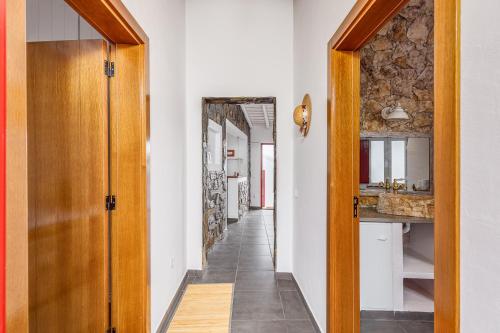 a hallway with a door leading to a kitchen with a sink at Casa do Jardim Secreto - Monsaraz in Santo António do Baldio
