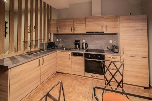 a kitchen with wooden cabinets and a stove top oven at Radost Residence The Heart of Unique Living in Prague