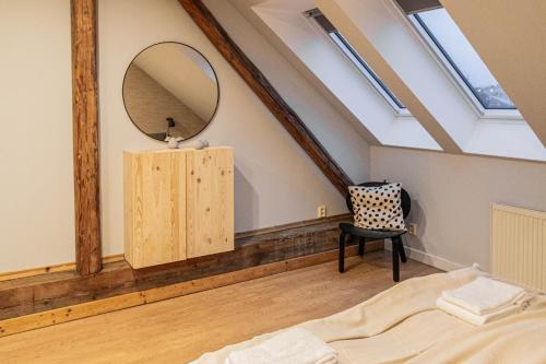 a bedroom with a mirror and a bed and a chair at Radost Residence The Heart of Unique Living in Prague