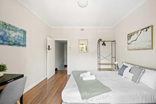 a bedroom with a large white bed and a desk at Rustic Queen Room in Glebe - Next to USYD - Shared Bathroom in Sydney