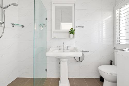 Un baño blanco con lavabo e inodoro. en Private Single Room - Conveniently Located at Glebe - Shared Bathroom, en Sídney
