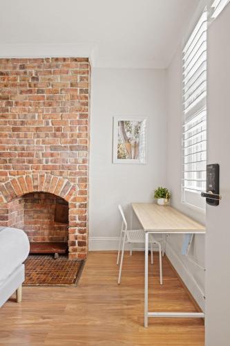 a living room with a brick fireplace and a table at Traditional Double Room in Glebe - Nearby USYD - Shared Bathroom in Sydney
