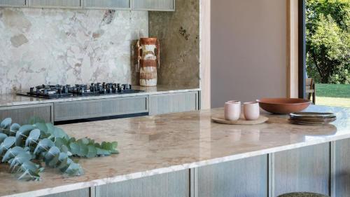 a kitchen with a counter with a stove top oven at Cedar Hill in Newrybar