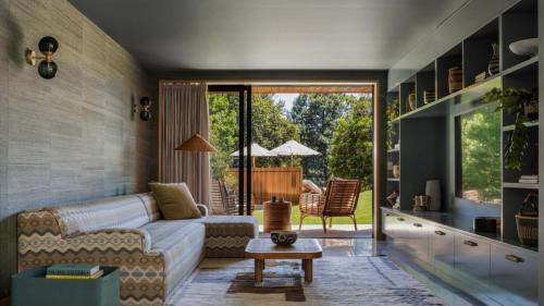 a living room with a couch and a table at Cedar Hill in Newrybar