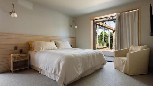 a bedroom with a bed and a window and a chair at Cedar Hill in Newrybar