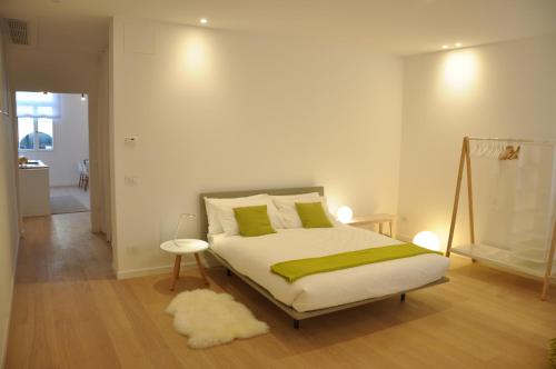 a bedroom with a bed with a green blanket and a rug at Appartamento Colonna in Murano