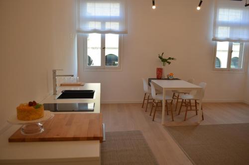 een keuken met een fornuis en een tafel met stoelen bij Appartamento Colonna in Murano